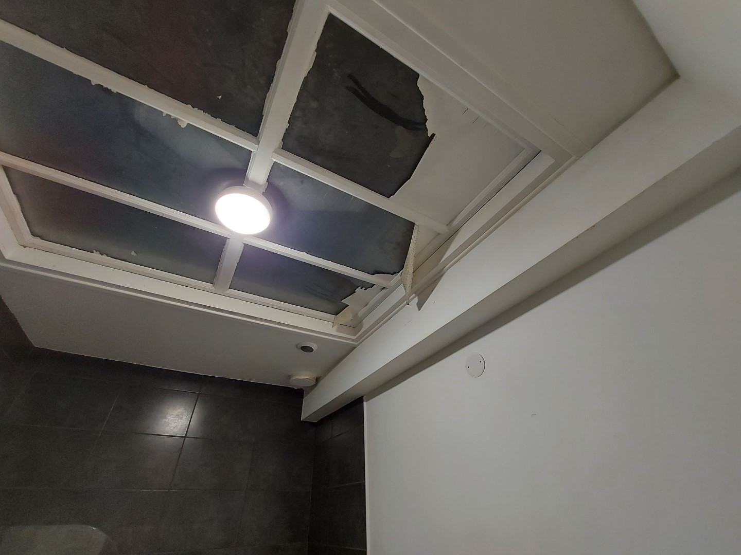 Décollement de peinture sous une verrière, car non adaptée au support
