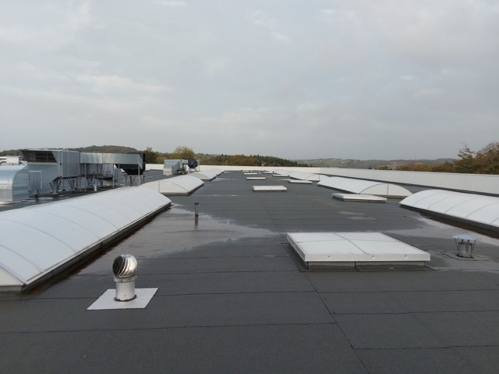 Stagnation d'eau sur une toiture-terrasse due à la contreflêche de la charpente en béton précontraint